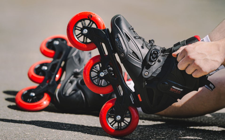 Powerslide Imperial Black Red 110 inline skate with black boot and three red 110 mm wheels in action